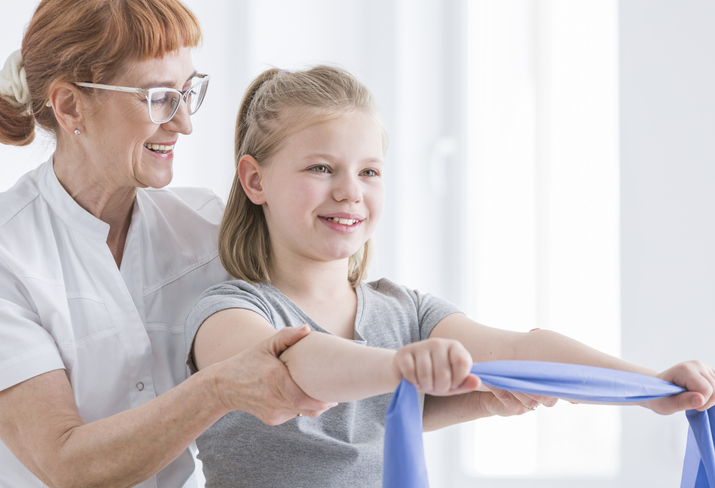 Young girl exercising with rubber resistance band